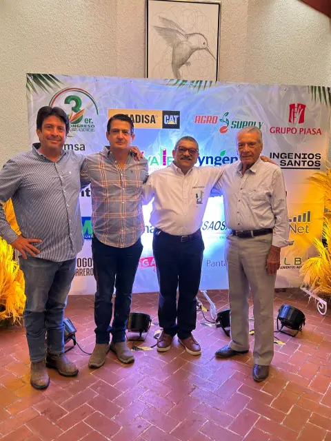 Invitados frente al muro de patrocinadores del congreso