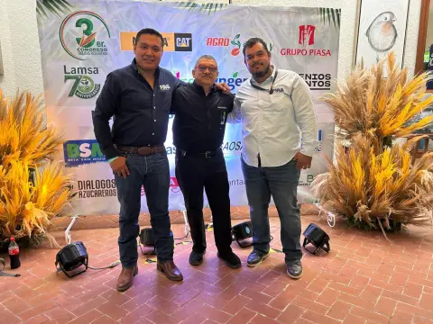 Invitados posando frente al muro de patrocinadores